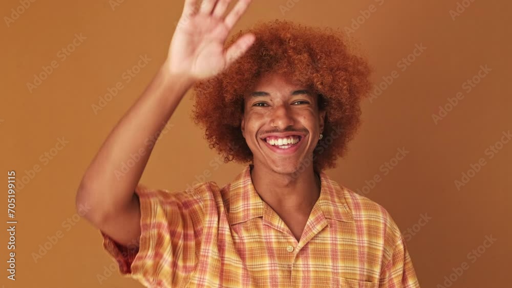 Close up, guy waving palm in greeting gesture isolated on brown background in studio Close up, guy waving palm in greeting gesture isolated on brown background in studio