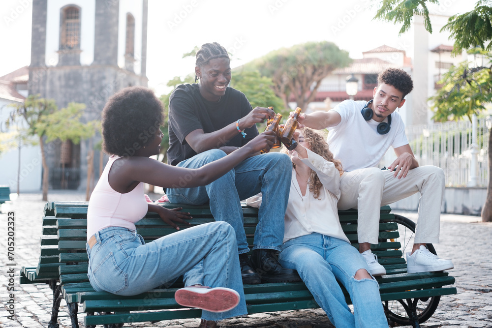 Group of young friends toasting outdoors and sharing a sunny afternoon. Concept: lifestyle