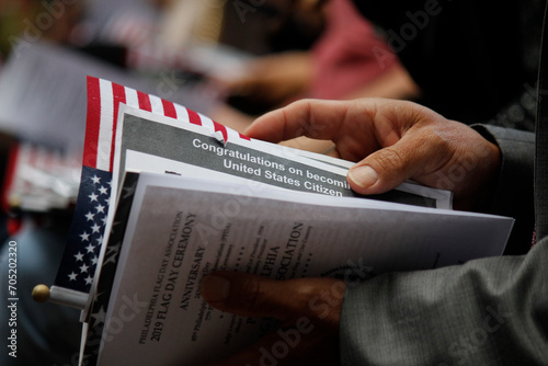 Close up detail of an immigrant's hand as he holds official welcome documents during the naturalization ceremony to become a U.S. citizen. photo
