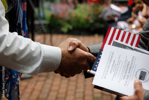 A new United States citizen receives a warm handshake and congratulations during a naturalization ceremony. photo