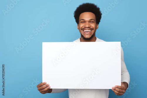 black man with afro hair, laughing, holding a sign with his hands, on blue background