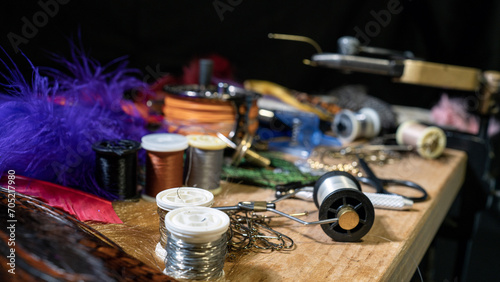 Tying a fly fishing fly. A set of various accessories and materials for tying fly fishing lures. Close-up. photo