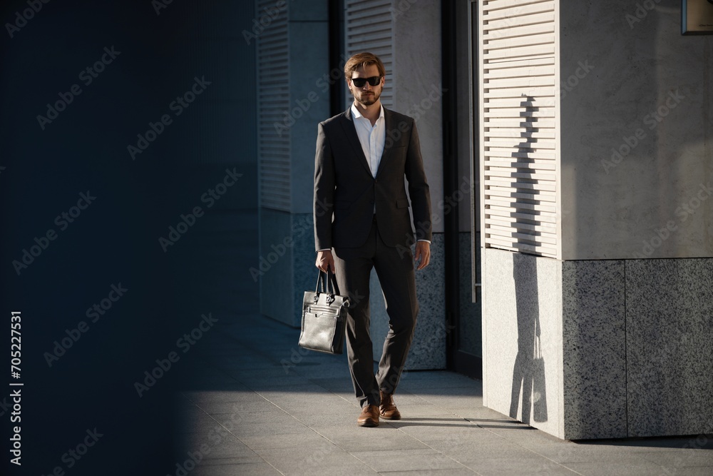 Elegant handsome man in classic suit standing near the office building. Elegant handsome man in classic suit standing near the office building.