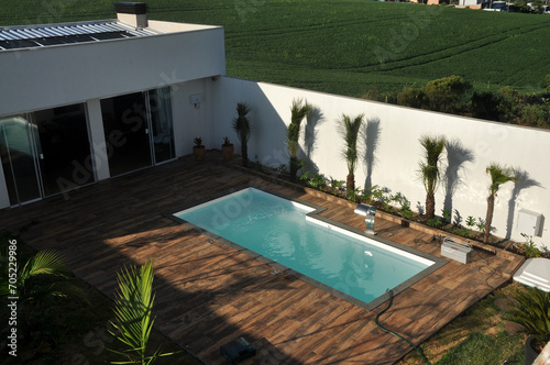 area externa de edicula com piscina e paisagismo com chão de porcelanato amadeirado deck  photo