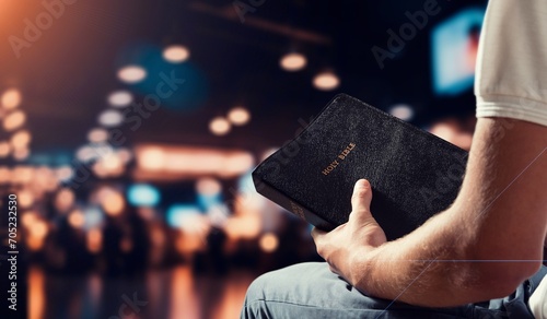 Man praying hold holy bible book