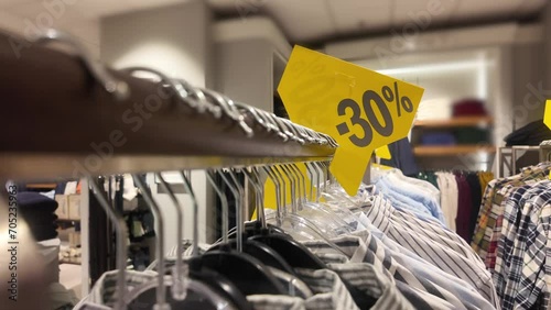 Sales signs in store, shopping discount sign on clothing rack, with designer shirts photo