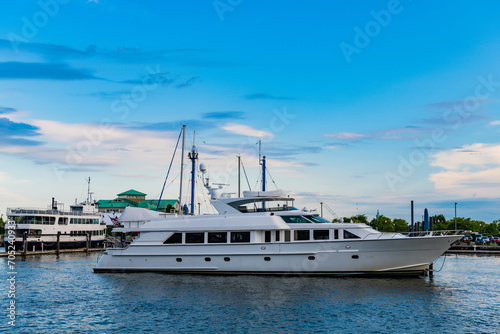 Summer vacation. Summertime yachting. Yacht vacation in summer. A luxury private motor yacht in sea harbor. Yacht in navigation. Private white luxury anchored off the beach. Superyacht at anchor