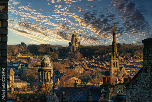Fotografía Historic cityscape at sunset with dramatic clouds, showcasing architectural landmarks and a warm golden light bathing the buildings in Lancaster