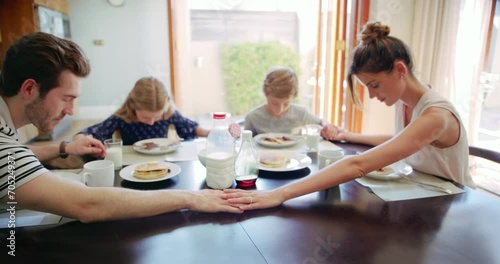 Breakfast, religious and family praying for food with gratitude for a meal in the morning in a home table. Children, parents and kids with spiritual mother and father pray to give thanks God photo