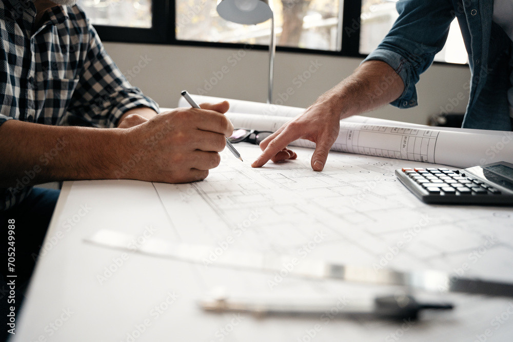 Fototapeta premium Architects engineer discussing at the table with blueprint - Closeup on hands and project print.