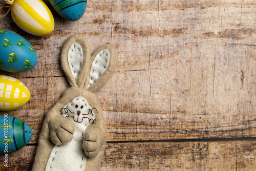 Easter Bunny and Colorful easter eggs on wooden background with copy space © SLindenau