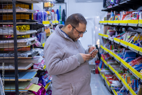 Male selecting school supplies for his kids in school supplies store © nooh