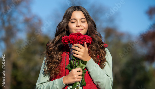 teenager girl smelling autumn flowers outdoor. teenager girl with autumn flowers bouquet.