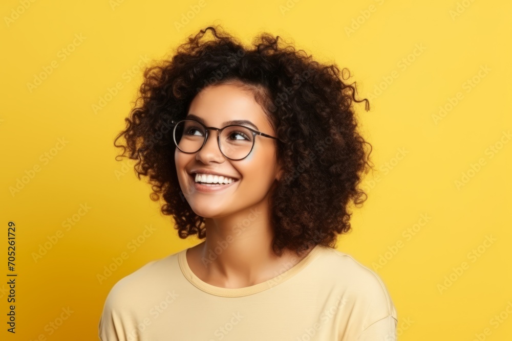Portrait of a happy young african american woman in glasses over yellow background Portrait of a happy young african american woman in glasses over yellow background