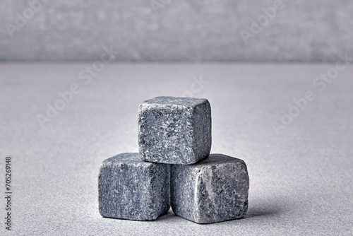 Three stone cubes on a gray concrete background. Backdrop template for product advertising