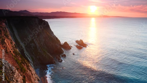 Sunset over rocky cliffs at Asturias coast in north Spain. View from Faro de Cabo Busto. Tourist attraction, place to visit. photo