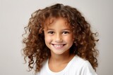 Portrait of a cute young girl with curly hair looking at camera