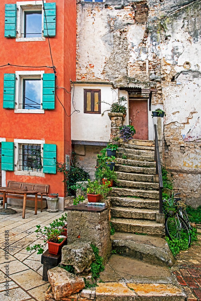 old steps in a courtyard with fresh homemade flowers in pots in Croatia