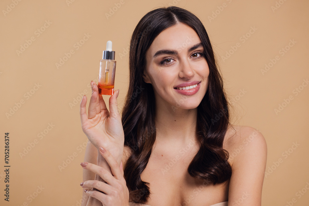 Happy young woman applying essential oil onto hair roots on beige background Happy young woman applying essential oil onto hair roots on beige background