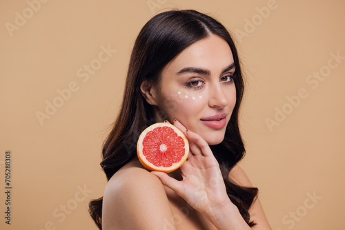 Young Woman Holding Grapefruit Applying Eye Cream Drops On Skin Under Eyes