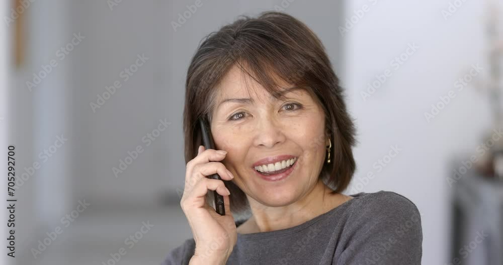 Smiling attractive woman happy enjoying talking on mobile phone looking at camera relaxing sitting at home closeup. Smiling attractive woman happy enjoying talking on mobile phone looking at camera relaxing sitting at home closeup.