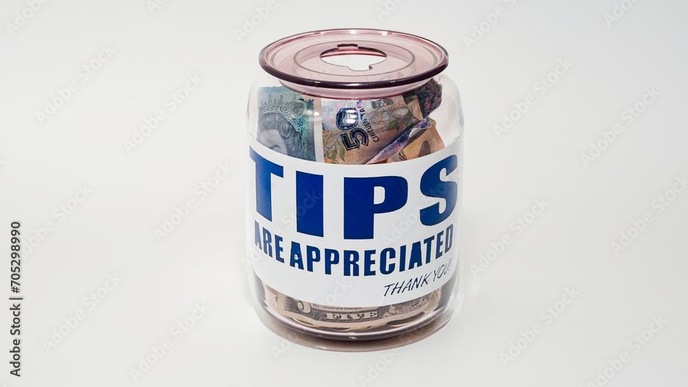 Jarro de propinas con billetes y monedas de varias denominaciones. Propinas de la industria de servicios, salario mínimo y concepto de propina como una forma única y creativa de almacenar dinero Jarro de propinas con billetes y monedas de varias denominaciones. Propinas de la industria de servicios, salario mínimo y concepto de propina como una forma única y creativa de almacenar dinero