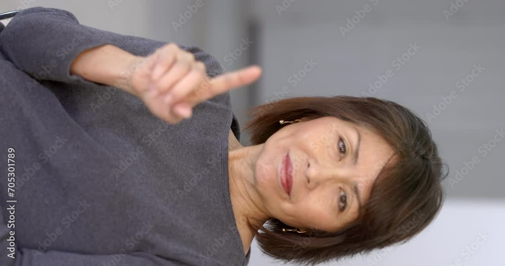 Playful attractive woman smiling looking at camera making funny hand finger gestures relaxing sitting at home closeup vertical. Playful attractive woman smiling looking at camera making funny hand finger gestures relaxing sitting at home closeup vertical.