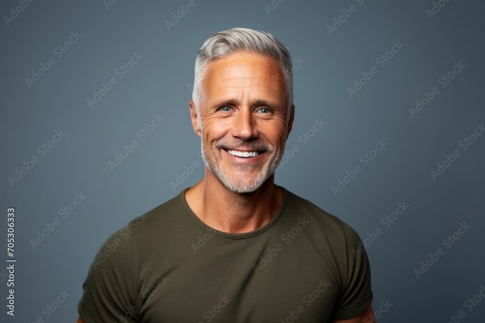 Portrait of a smiling mature man with grey hair against blue background Portrait of a smiling mature man with grey hair against blue background