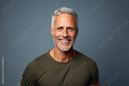 Portrait of a smiling mature man with grey hair against blue background
