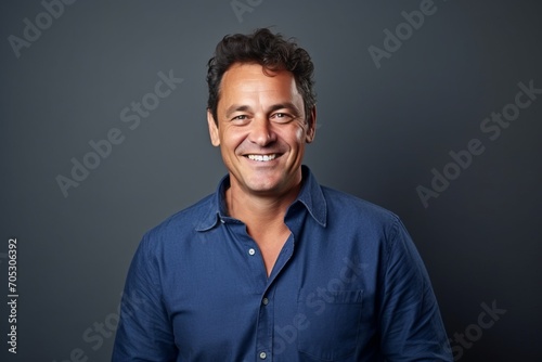 Portrait of a happy middle-aged man smiling at the camera against grey background