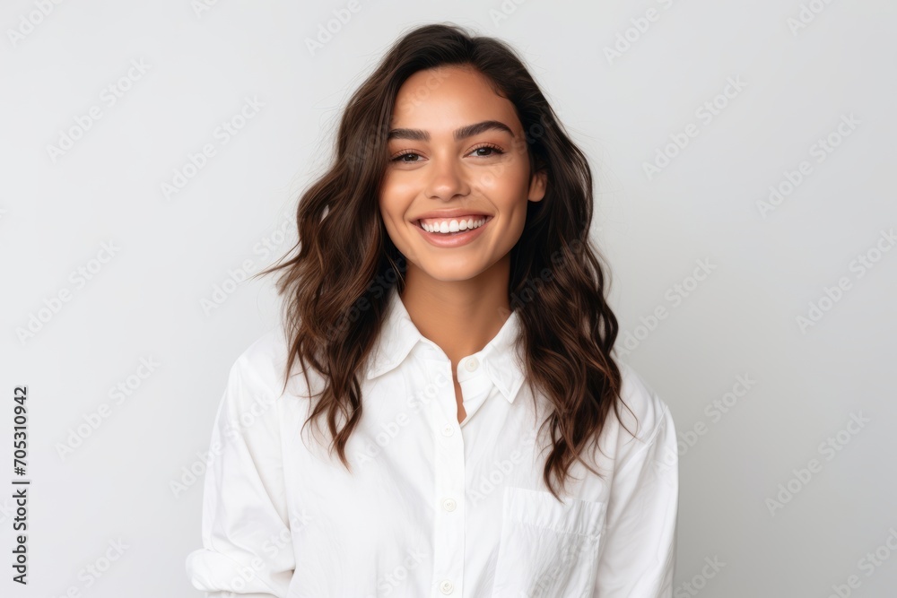 Portrait of smiling young businesswoman in white shirt, isolated on grey background Portrait of smiling young businesswoman in white shirt, isolated on grey background