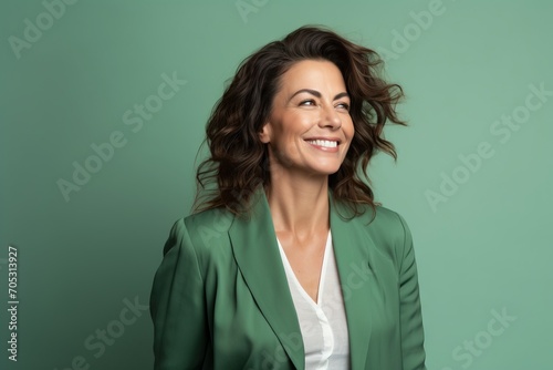 smiling businesswoman in green jacket looking up isolated on green background