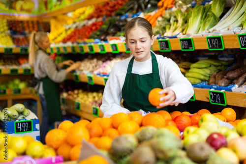 Portrait of smiling girl who works part-time in a store as a trainee seller