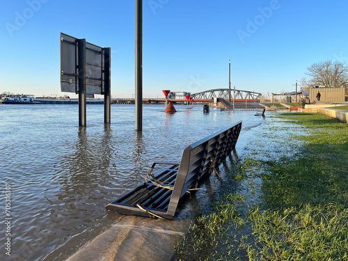 Panoramic view of flooded countenance boulevard of Zutphen with high water level of river IJssel and barrier fence under water at sunset. photo