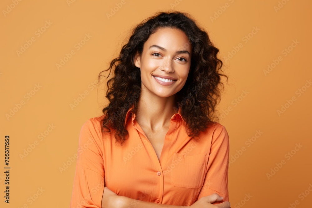 smiling african american woman in orange shirt over yellow background smiling african american woman in orange shirt over yellow background
