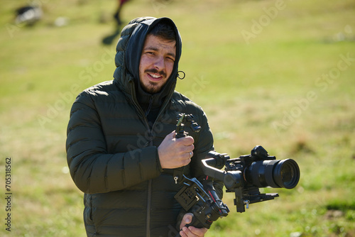 A skilled videographer, equipped with professional gear, captures the essence of nature's beauty, expertly documenting the scenic landscape in a cinematic masterpiece that reflects the seamless blend photo