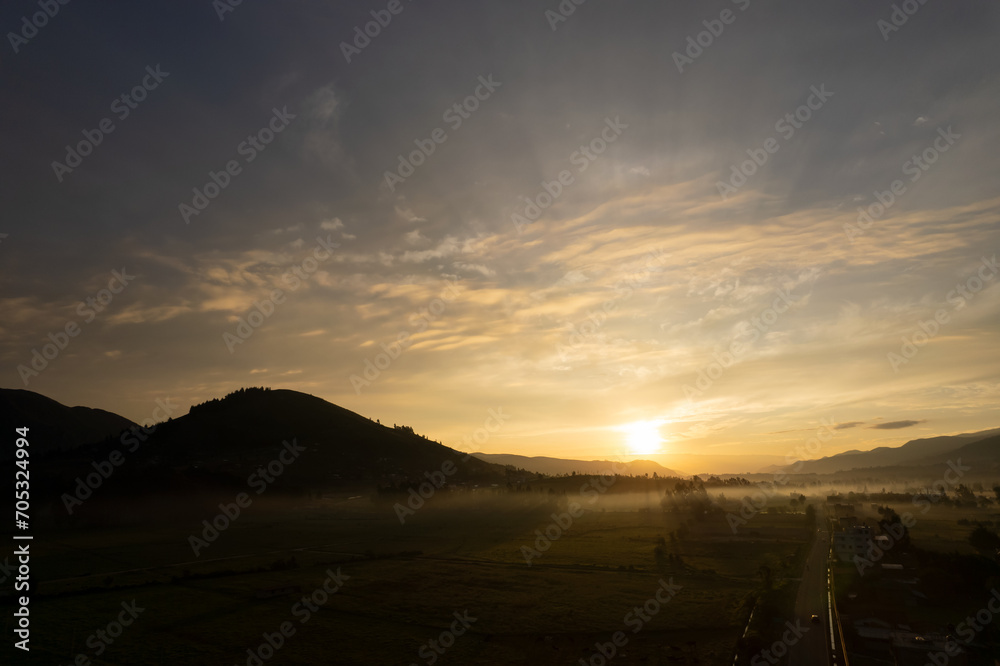 foto de amanecer en valle, con cerros y arboles, alto contraste