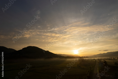 foto de amanecer en valle, con cerros y arboles, alto contraste