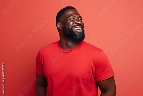 Portrait of a happy african american man laughing against red background