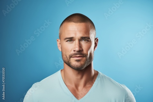 Portrait of a handsome young man on a blue background. Men's beauty, fashion. © Inigo