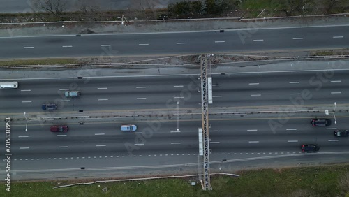 cars driving on a busy highway road (aerial drone view) freeway interstate (van wyck expressway in new york city) cemetery background sunset footage (from above) photo