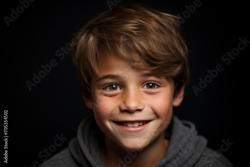 Portrait of a cute boy on a black background. Close-up.