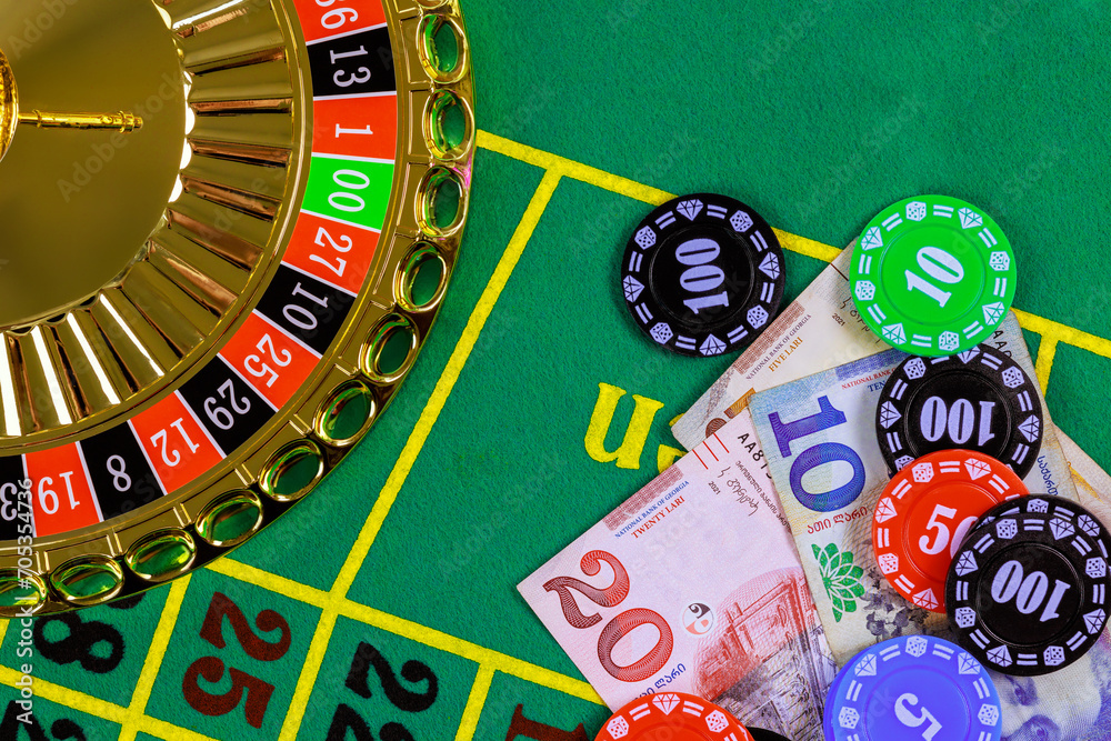 Casino roulette is on green gaming table with Georgian banknotes lari, poker chips. Casino roulette is on green gaming table with Georgian banknotes lari, poker chips.