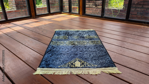 Obraz na plátně The gray prayer mat or sajadah for prayer or salat on the wooden floor gives a c