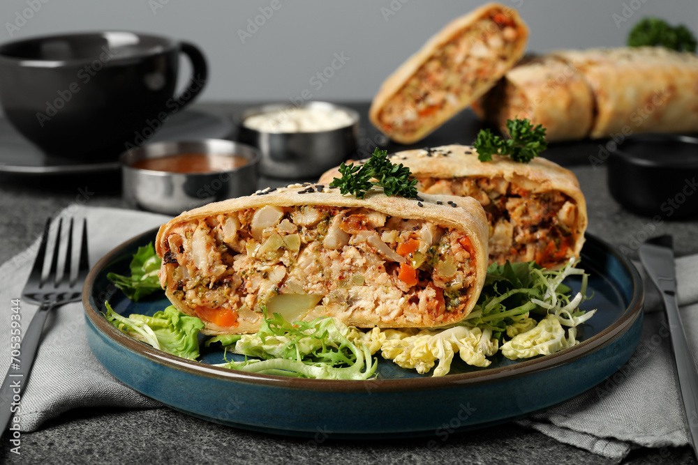 Pieces of delicious strudel with chicken and vegetables served on grey textured table, closeup Pieces of delicious strudel with chicken and vegetables served on grey textured table, closeup