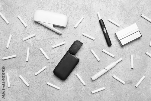 Composition with modern electronic cigars and sticks on grey grunge table