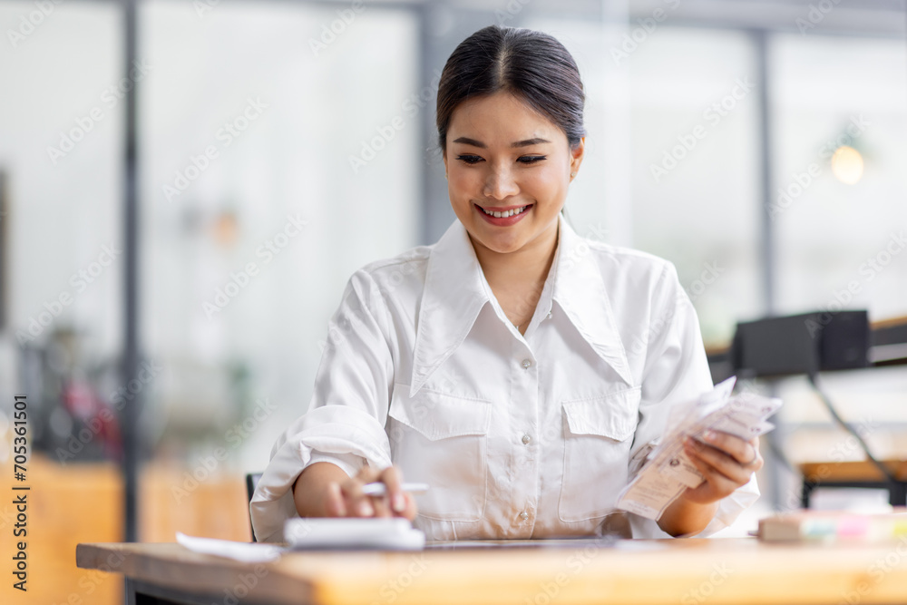 asian woman using calculator and calculate bills in home office. tax form us business income office Financial document. Tax time.Tax concept. asian woman using calculator and calculate bills in home office. tax form us business income office Financial document. Tax time.Tax concept.