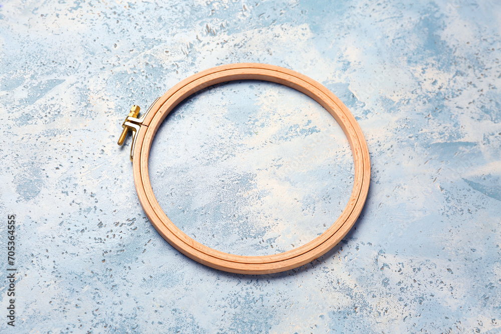 Wooden embroidery hoop on grunge blue background Wooden embroidery hoop on grunge blue background