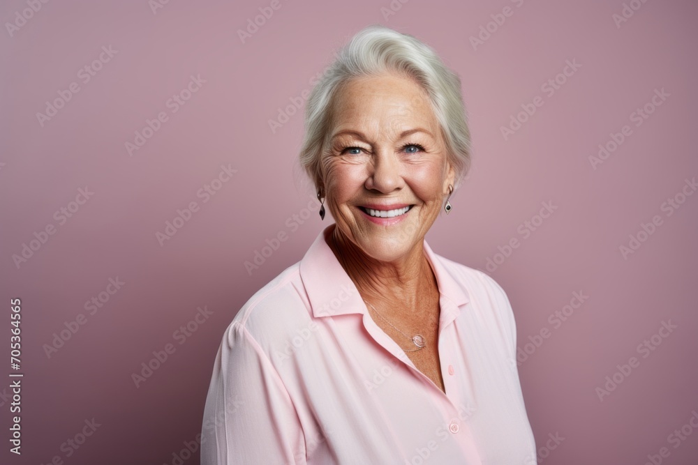 Portrait of a happy senior woman smiling at the camera against pink background Portrait of a happy senior woman smiling at the camera against pink background
