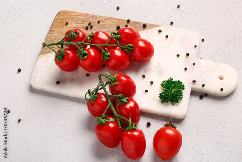 Board with fresh cherry tomatoes and peppercorn on white background